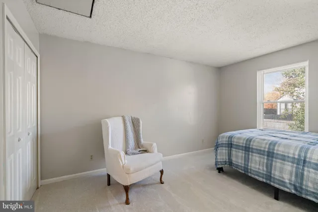 a bedroom with a bed chair and window