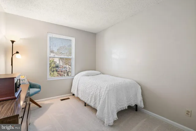 a bed sitting in a bedroom next to a window