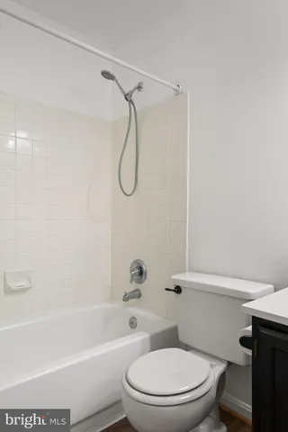 a white toilet and tub sitting next to a bathroom sink