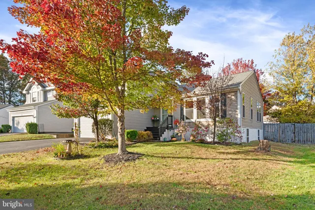 a front view of a house with a yard fountain and a tree