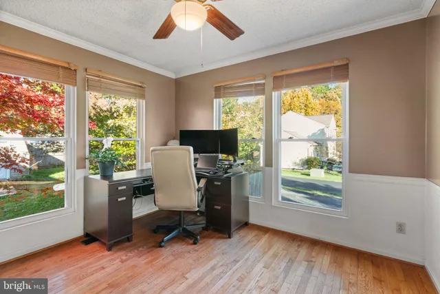 a view of a workspace with furniture and a window