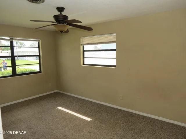 an empty room with a window and a fan
