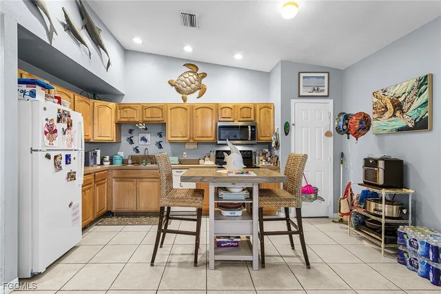 a kitchen with stainless steel appliances kitchen island granite countertop a refrigerator and microwave