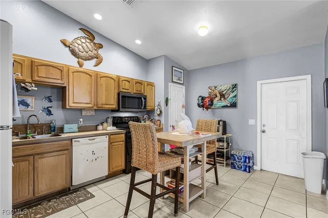 a view of a kitchen with dining area a sink and a refrigerator