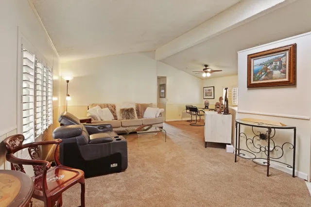 a living room with furniture a dining table and kitchen view