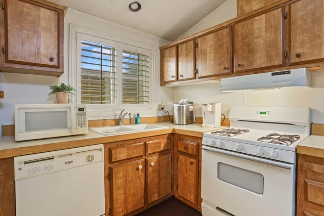 a bedroom with a bed a chandelier and a chair
