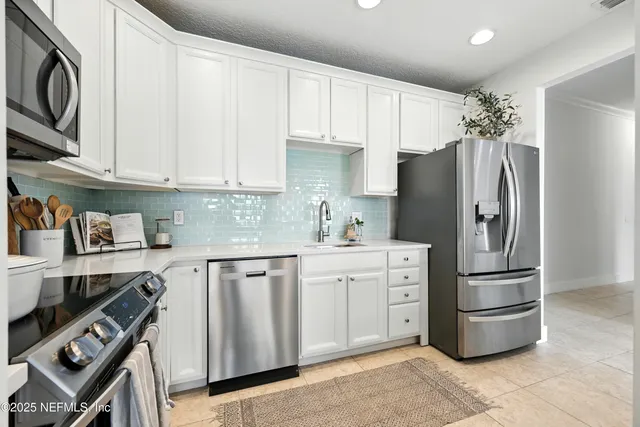 a kitchen with stainless steel appliances a refrigerator sink and cabinets