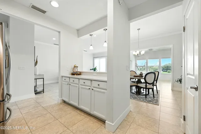 a large bathroom with a sink a chair and a glass door shower