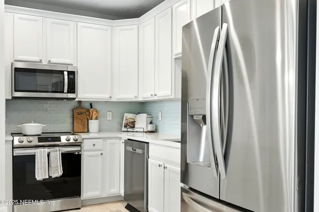 a kitchen with stainless steel appliances a refrigerator sink and microwave