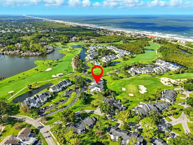 an aerial view of a house with a garden and lake view