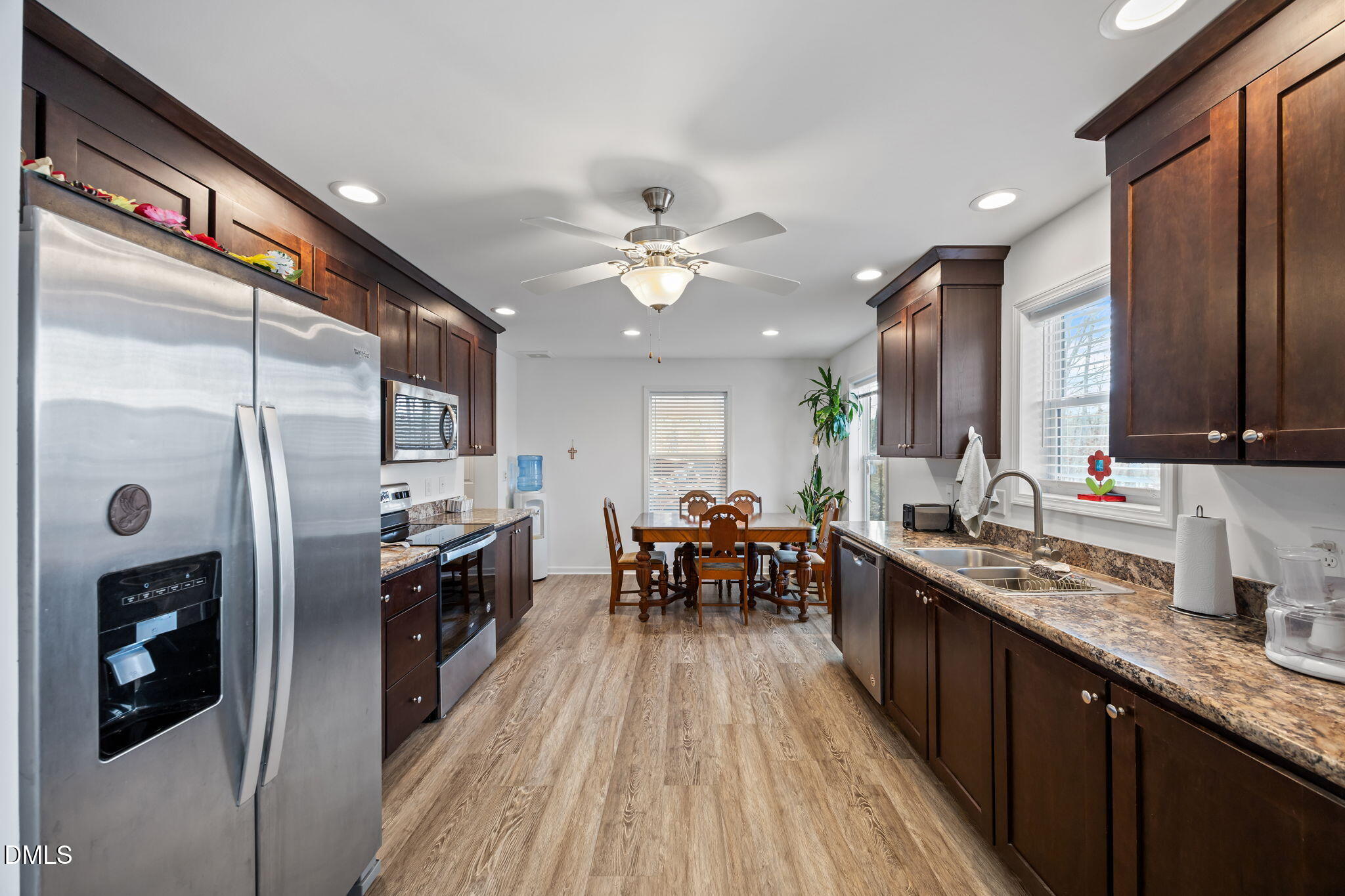 58 Lakefront Road Prospect Hill, NC 27314 - Photo 23 of 45 a kitchen with stainless steel appliances granite countertop a refrigerator a sink dishwasher a stove and a dining table with wooden floor
