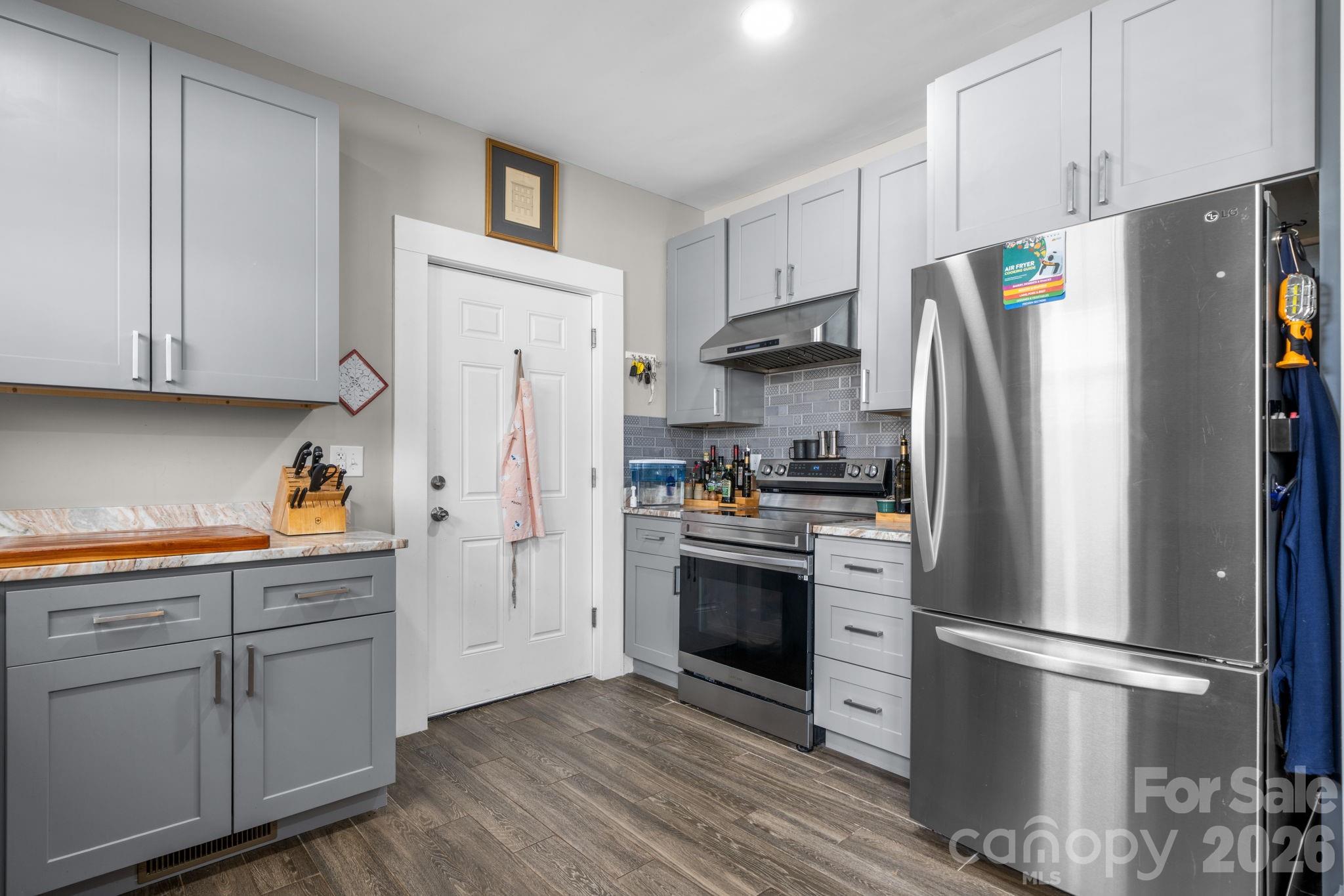 115 12th Street Southwest Hickory, NC 28602 - Photo 14 of 35 a kitchen with stainless steel appliances a refrigerator stove and white cabinets