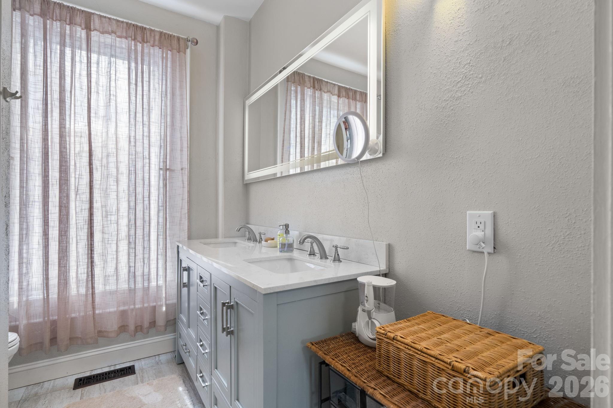 115 12th Street Southwest Hickory, NC 28602 - Photo 21 of 35 a bathroom with a sink a mirror and a toilet