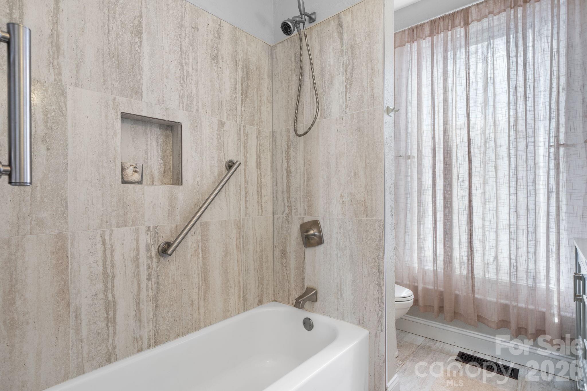 115 12th Street Southwest Hickory, NC 28602 - Photo 22 of 35 a bathroom with a shower curtain and a bathtub