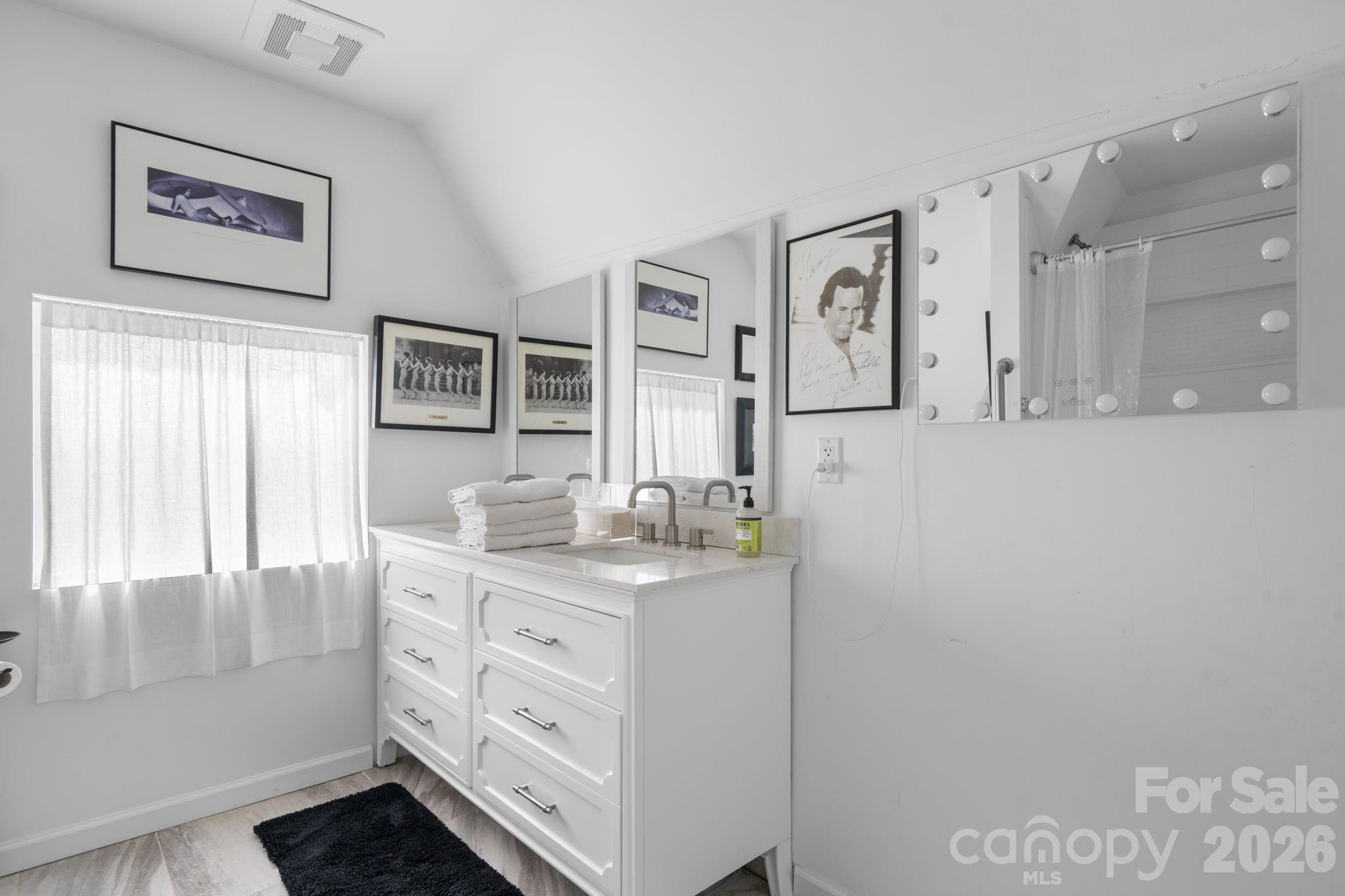 115 12th Street Southwest Hickory, NC 28602 - Photo 30 of 35 a bathroom with a granite countertop sink a mirror a vanity and a shower