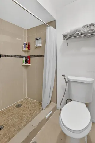 a bathroom with a toilet and a shower