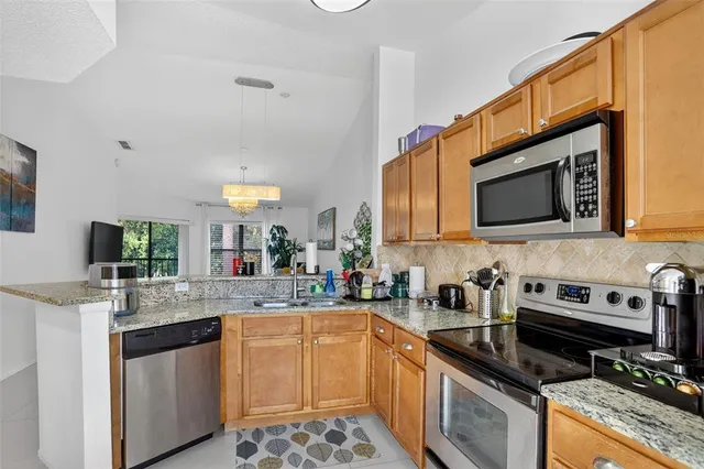 a kitchen with stainless steel appliances granite countertop a sink stove and microwave