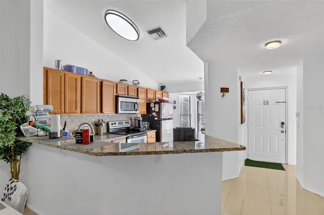 a kitchen with stainless steel appliances granite countertop a sink a stove and a refrigerator