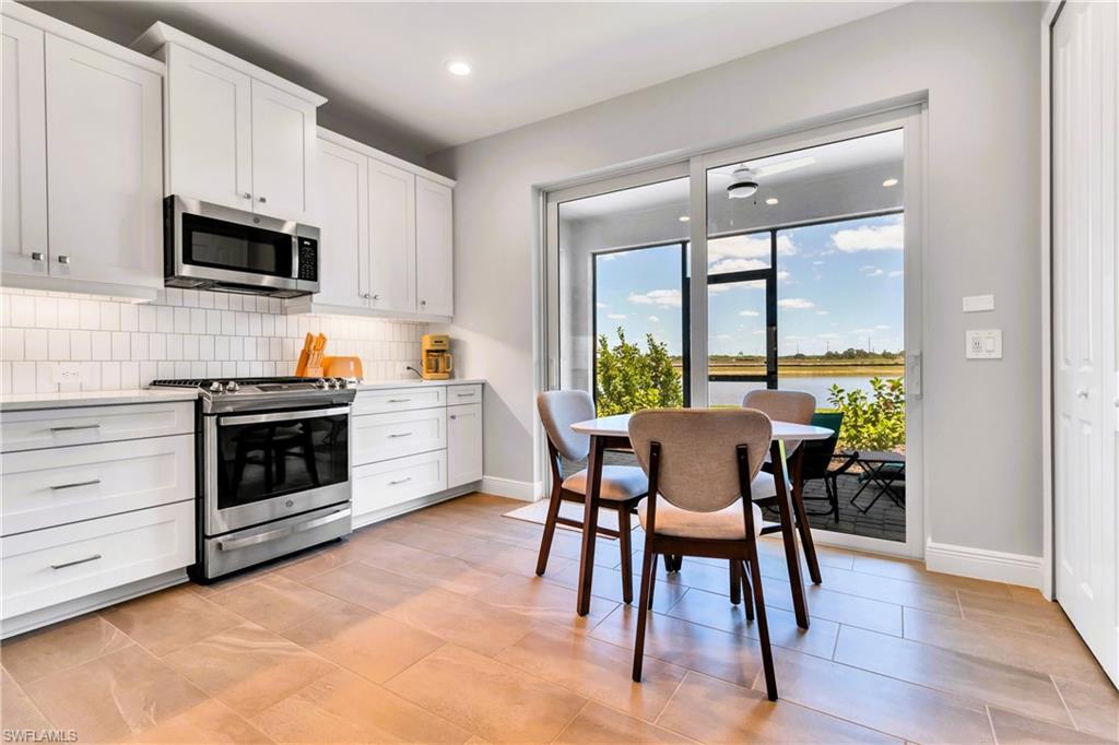 4664 Centaurus Circle Naples, FL 34120 - Photo 13 of 37 a kitchen with a table chairs microwave and cabinets