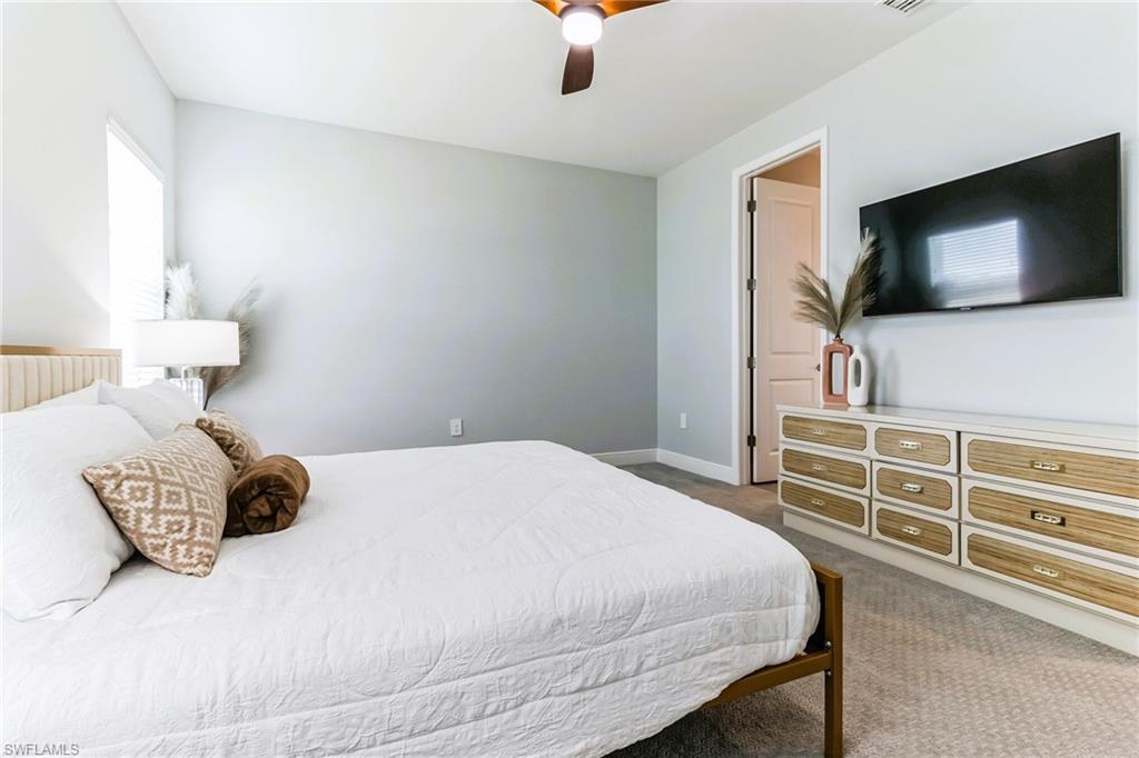 4664 Centaurus Circle Naples, FL 34120 - Photo 15 of 37 a bedroom with a bed and a flat screen tv
