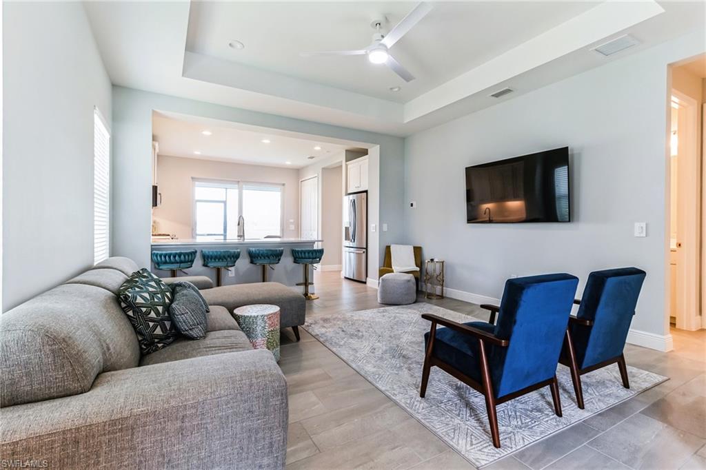 4664 Centaurus Circle Naples, FL 34120 - Photo 4 of 37 a living room with furniture and a flat screen tv
