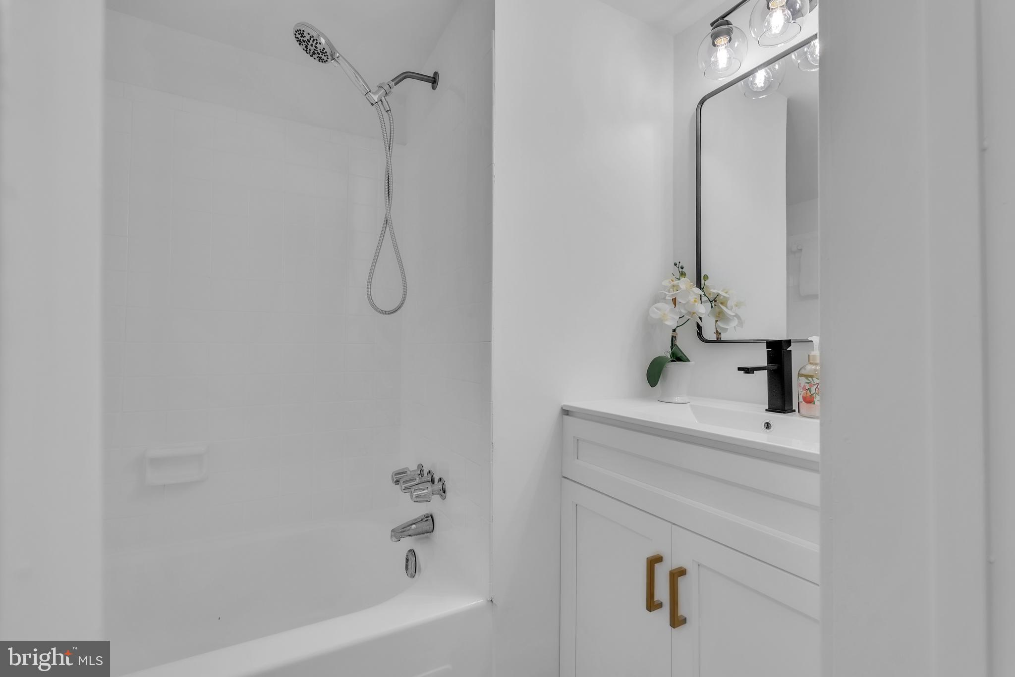 8074 Inverness Ridge Road Potomac, MD 20854 - Photo 31 of 41 a bathroom with a bathtub sink vanity and mirror