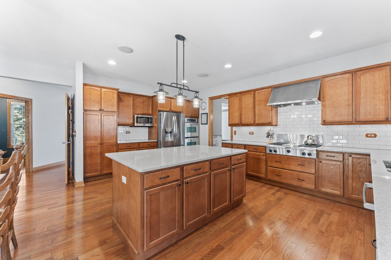9307 Daniel Lane Spring Grove, IL 60081 - Photo 21 of 70 a kitchen with stainless steel appliances granite countertop a sink a stove and a refrigerator