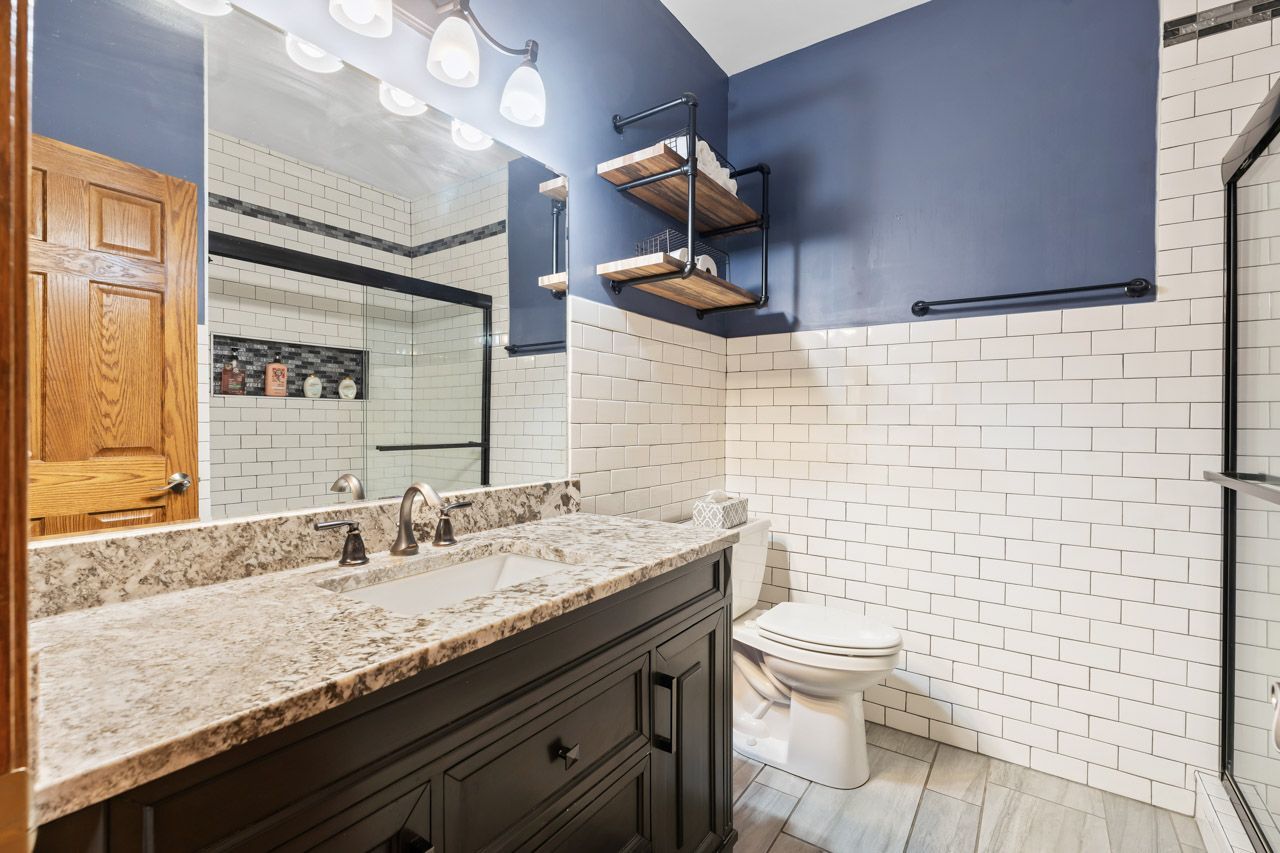 9307 Daniel Lane Spring Grove, IL 60081 - Photo 36 of 70 a bathroom with a granite countertop toilet a sink and a mirror
