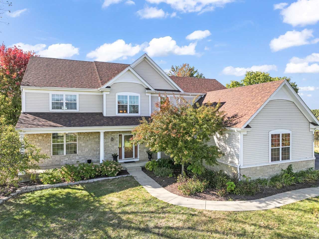 9307 Daniel Lane Spring Grove, IL 60081 - Photo 5 of 70 a view of a white house next to a yard with plants and trees