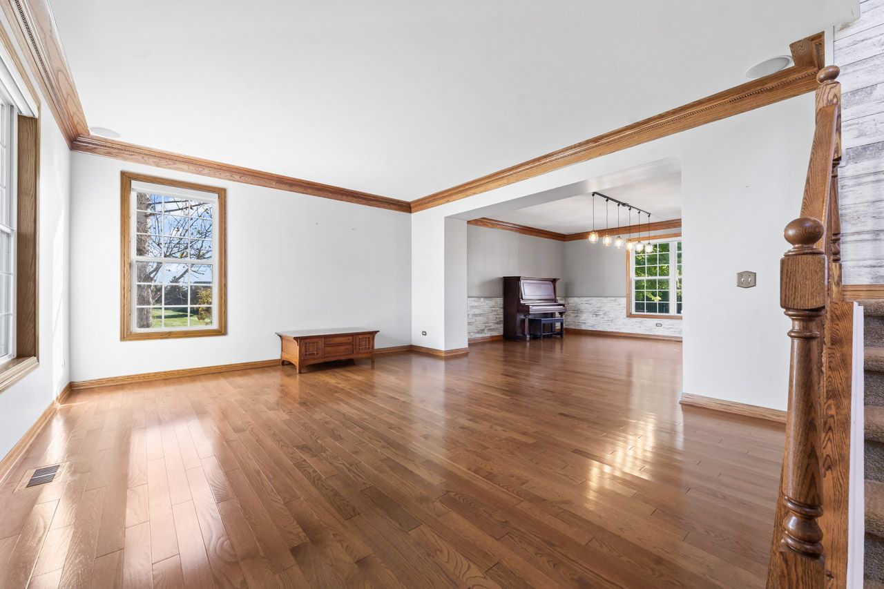 9307 Daniel Lane Spring Grove, IL 60081 - Photo 10 of 70 a view of empty room with wooden floor and floor to ceiling window
