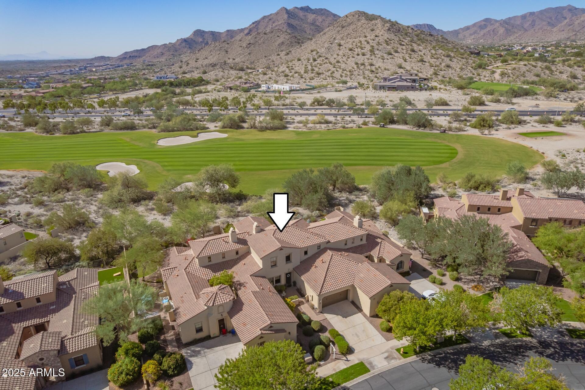 an aerial view of ocean and residential houses with outdoor space