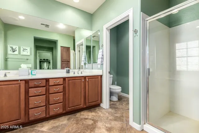 a bathroom with a double vanity sink mirror and toilet