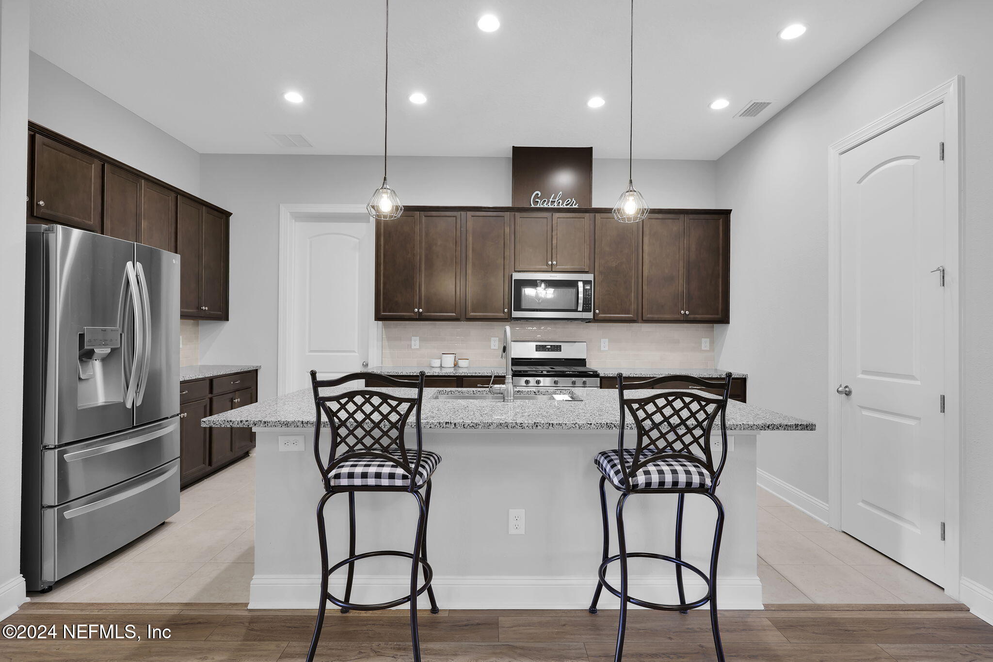 217 Liberty Bell Road Ponte Vedra, FL 32081 - Photo 7 of 50 a kitchen with stainless steel appliances wooden floor and a refrigerator