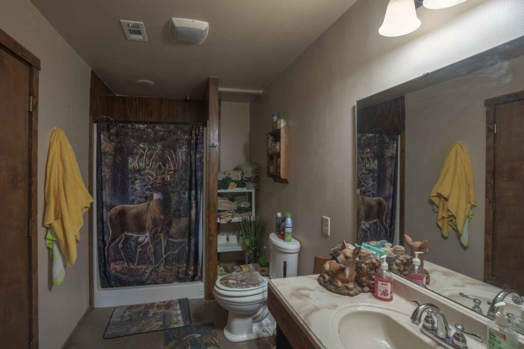 24 County Road 24 Junction, TX 76849 - Photo 25 of 37 a bathroom with a granite countertop sink a toilet and shower