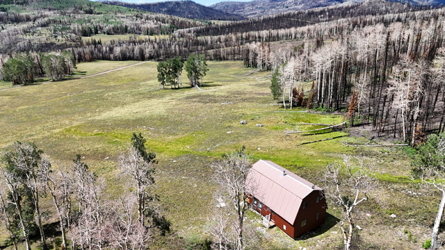123 Tbd Monroe Canyon Road Monroe, UT 84754 - Photo 15 of 92 Spacious natural landscape featuring a single barn-style structure with a brown metal roof, set amidst open fields and distant forested hills