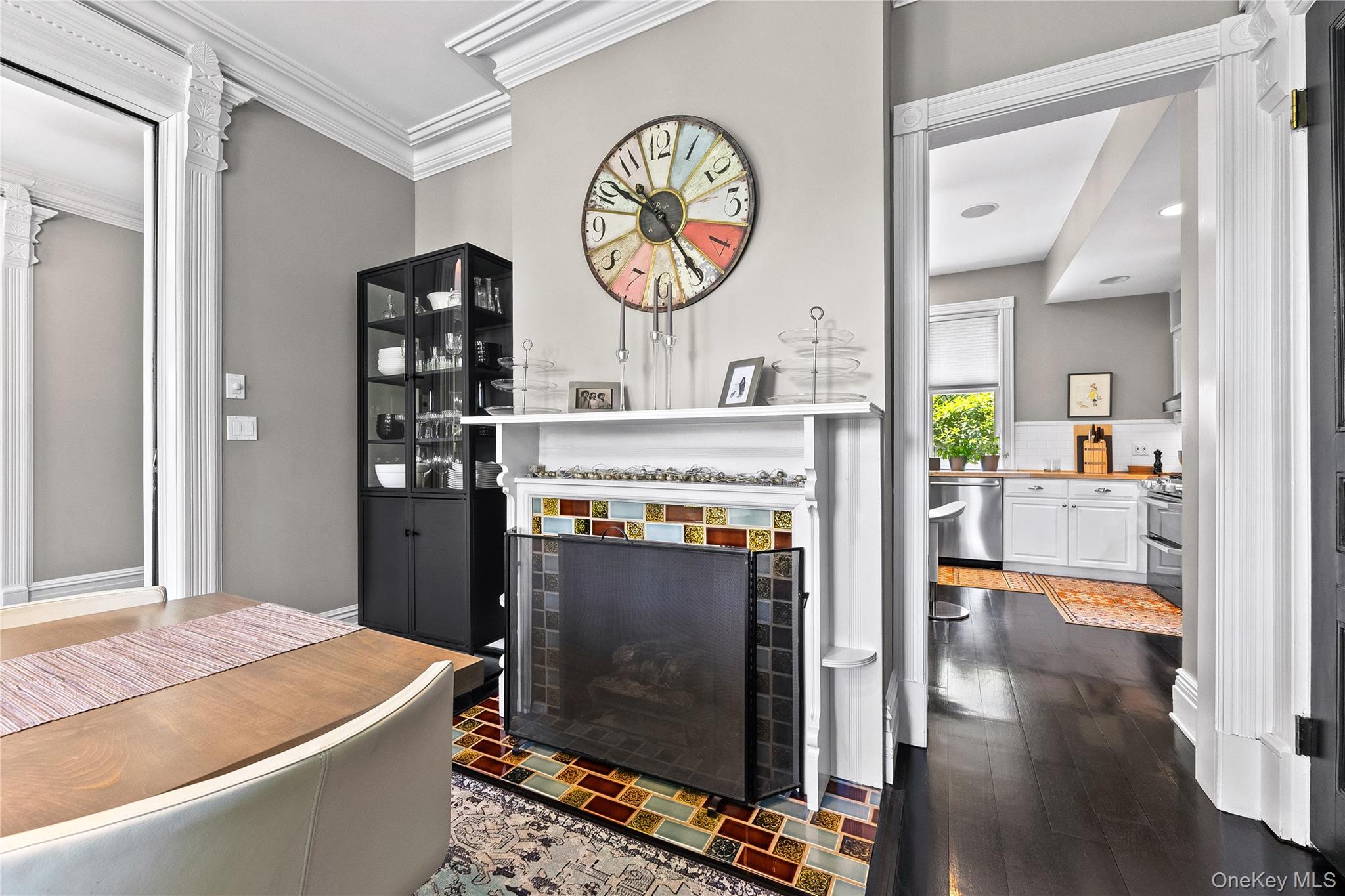 19 Howe Place Bronxville, NY 10708 - Photo 10 of 37 Decorative fireplace in formal dining area with an ornate white mantel and colorful tile surround, complemented by dark wood-finish flooring.
