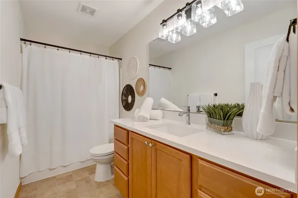 a bathroom with a sink a toilet and a mirror