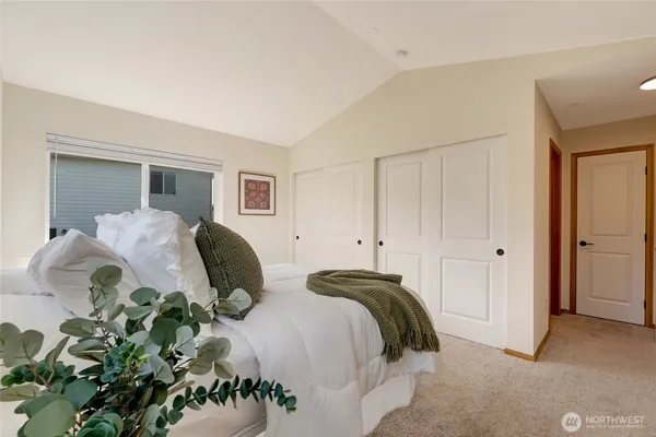 a bedroom with a bed mirror and window