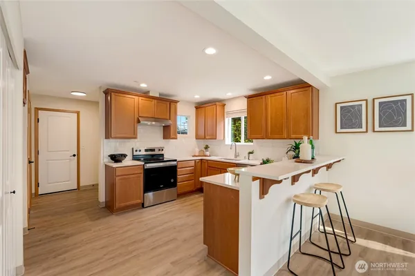 a large kitchen with stainless steel appliances granite countertop a stove and a refrigerator