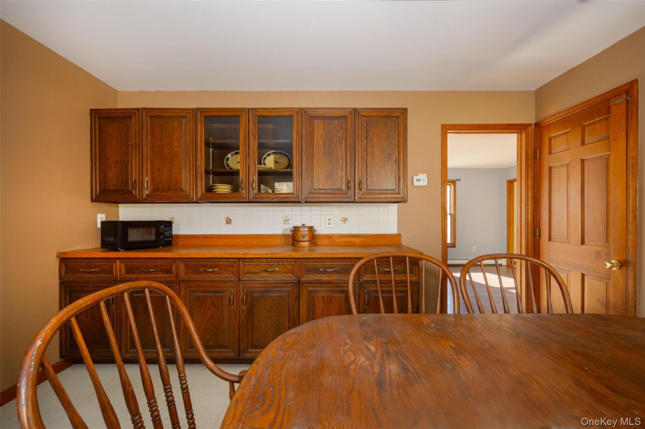 123 Brush Hill Road Millbrook, NY 12545 - Photo 11 of 29 Kitchen featuring glass insert cabinets, tasteful backsplash, and brown cabinetry