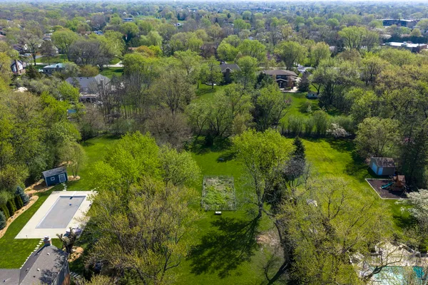 an aerial view of residential houses with outdoor space and trees