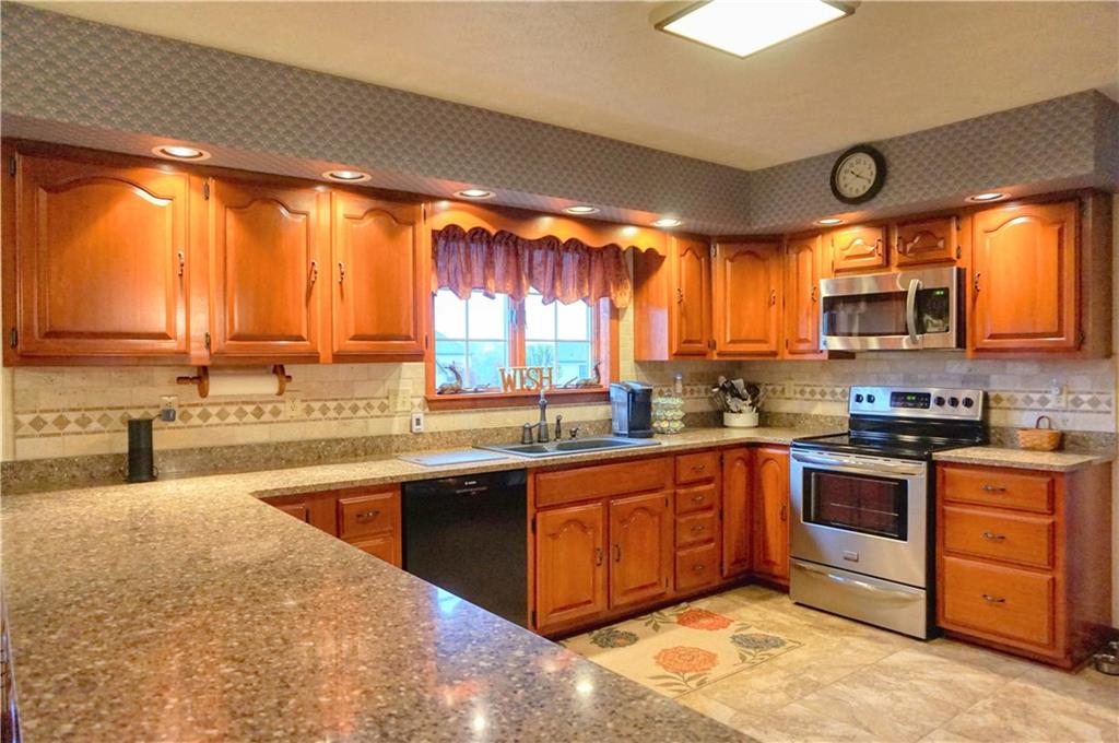 212 Holyoke Road Butler, PA 16001 - Photo 7 of 25 The gourmet kitchen is complimented with quartz counters, ceramic backsplash, plenty of cabinet space, ceramic flooring, stainless stove/microwave/refrigerator and Bosch dishwasher!