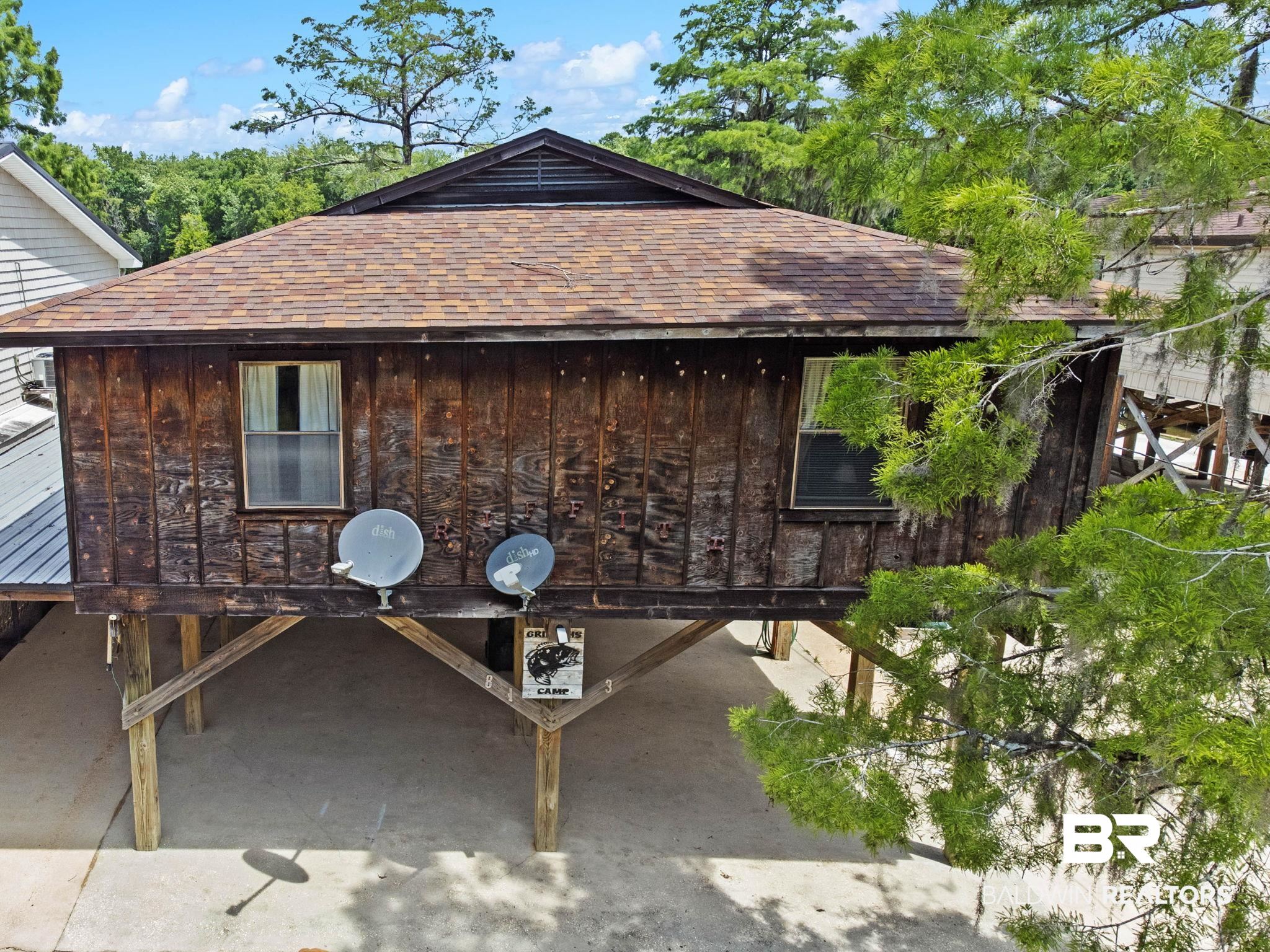 8153 Bryant's Lndg Road Stockton, AL 36579 - Photo 50 of 87 Stilted wood-sided structure featuring a composite shingle roof, multiple windows, and a covered ground-level area