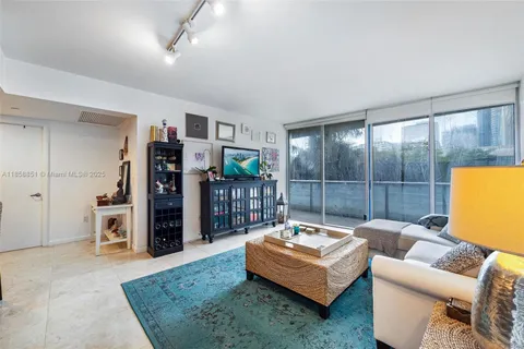 a living room with furniture a couch and a bookshelf with wooden floor