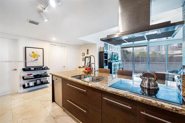 a kitchen with kitchen island a sink stove and refrigerator