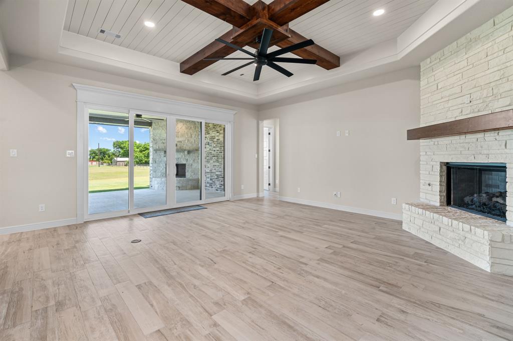 161 Frontera Drive Decatur, TX 76234 - Photo 8 of 39 Spacious Living Room offers a Gas Fireplace, Wood Beamed Ceiling & Great Covered Patio Access