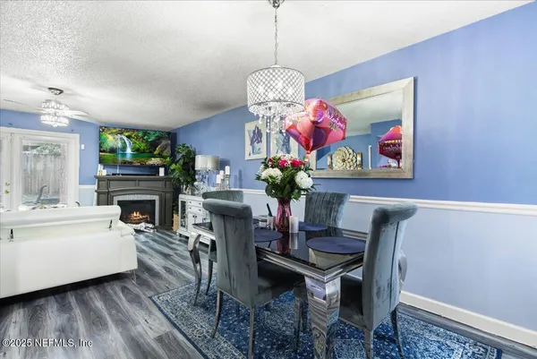 a view of a dining room with furniture a chandelier and wooden floor