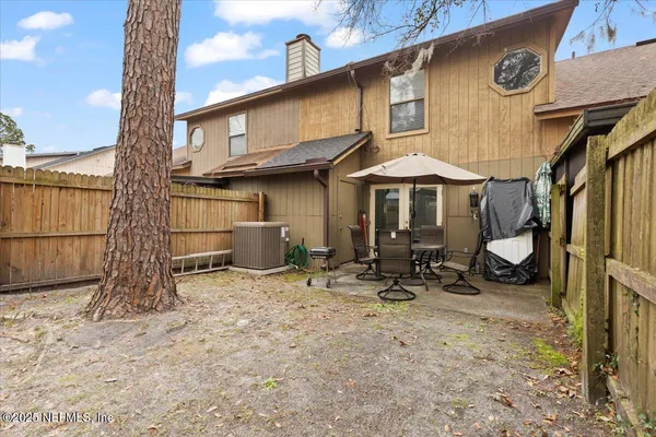 a backyard of a house with table and chairs