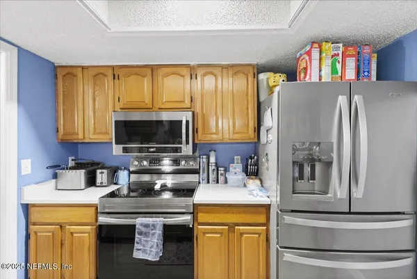 a kitchen with stainless steel appliances granite countertop a refrigerator and a stove top oven