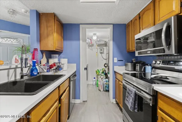 a kitchen with stainless steel appliances a sink a stove and a microwave